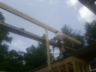 Carpenter setting a ridge beam over a new addition frame — Ice Dam Removal by Roofing Brothers in Columbus